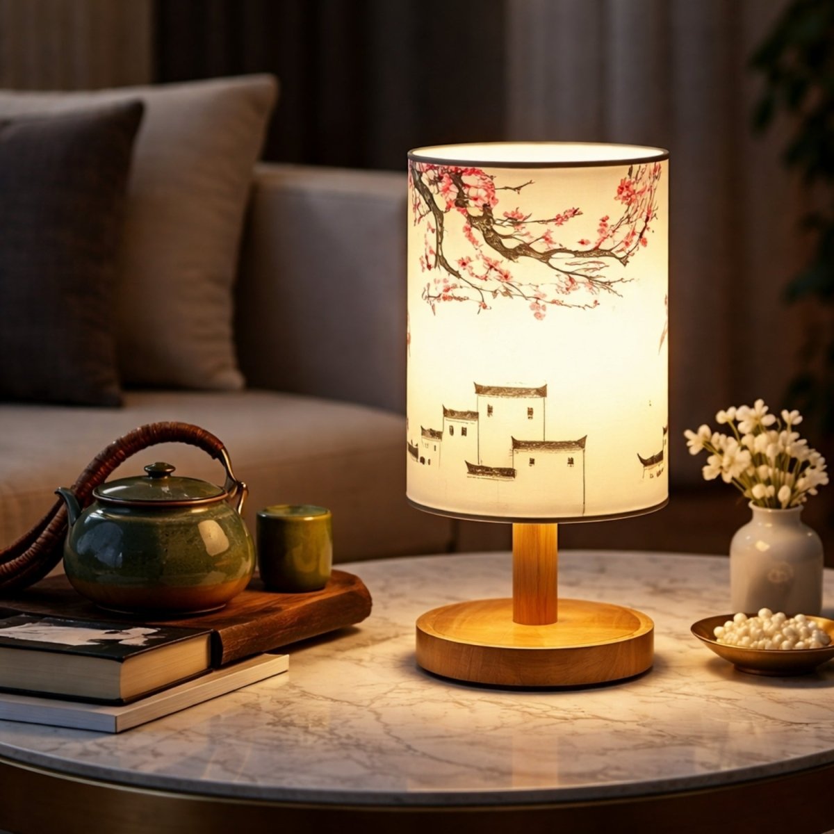 Rechargeable rubberwood table lamp by Kouvr featuring traditional Asian architecture and cherry blossom prints, illuminating a curated coffee table with a tea set