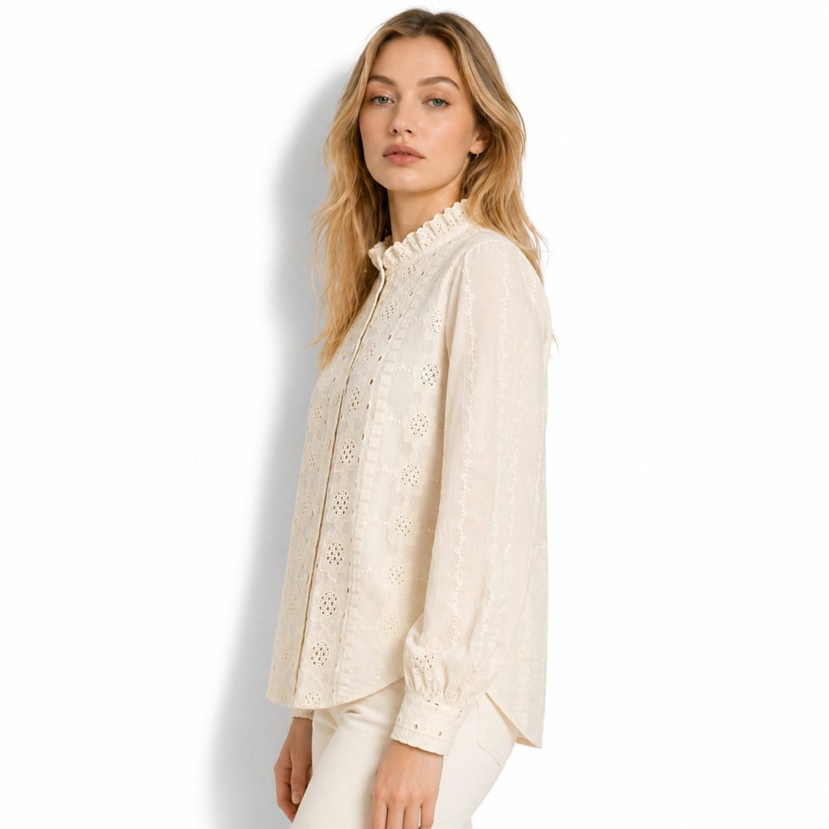 Side profile of woman modeling an off-beige romantic ruffled lace top showcasing long balloon sleeves and relaxed tailored fit.