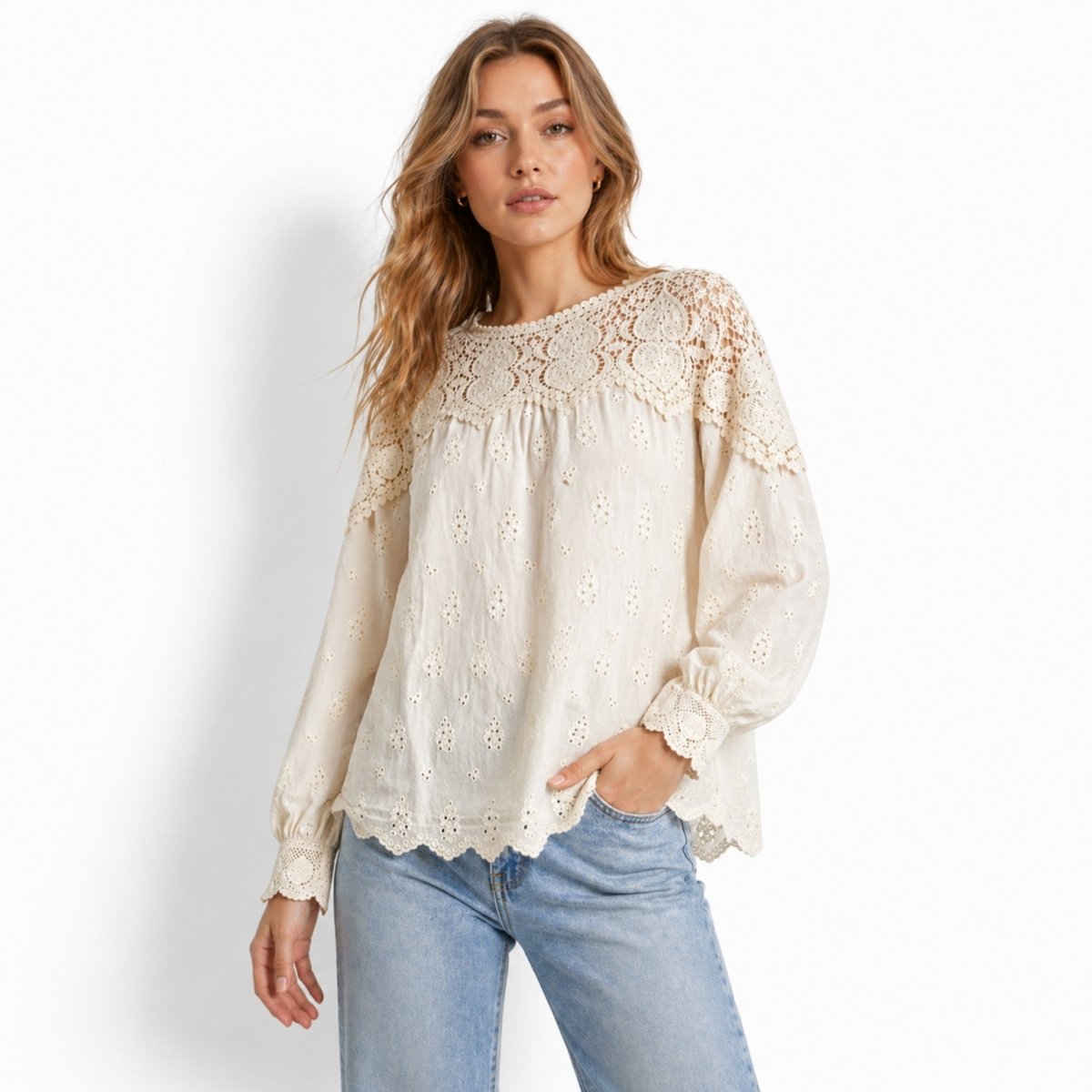 Woman wearing Kouvr beige crochet lace yoke broderie anglaise long sleeve blouse with light blue jeans, front lifestyle view