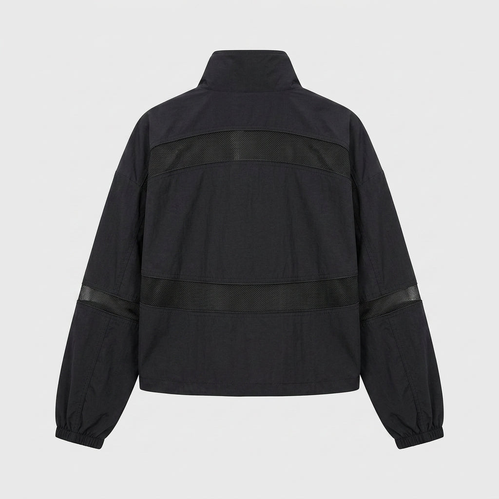 Woman opening car door wearing Kouvr black cropped mesh insert jacket in a gritty urban setting