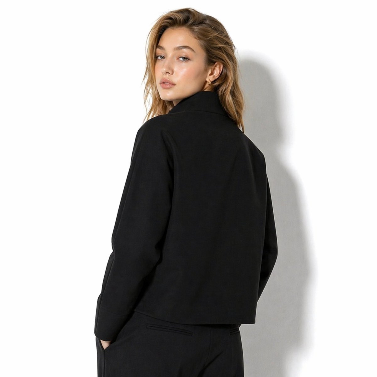 Back detail over the shoulder of the women's black long sleeve structured transitional outerwear jacket by Kouvr.