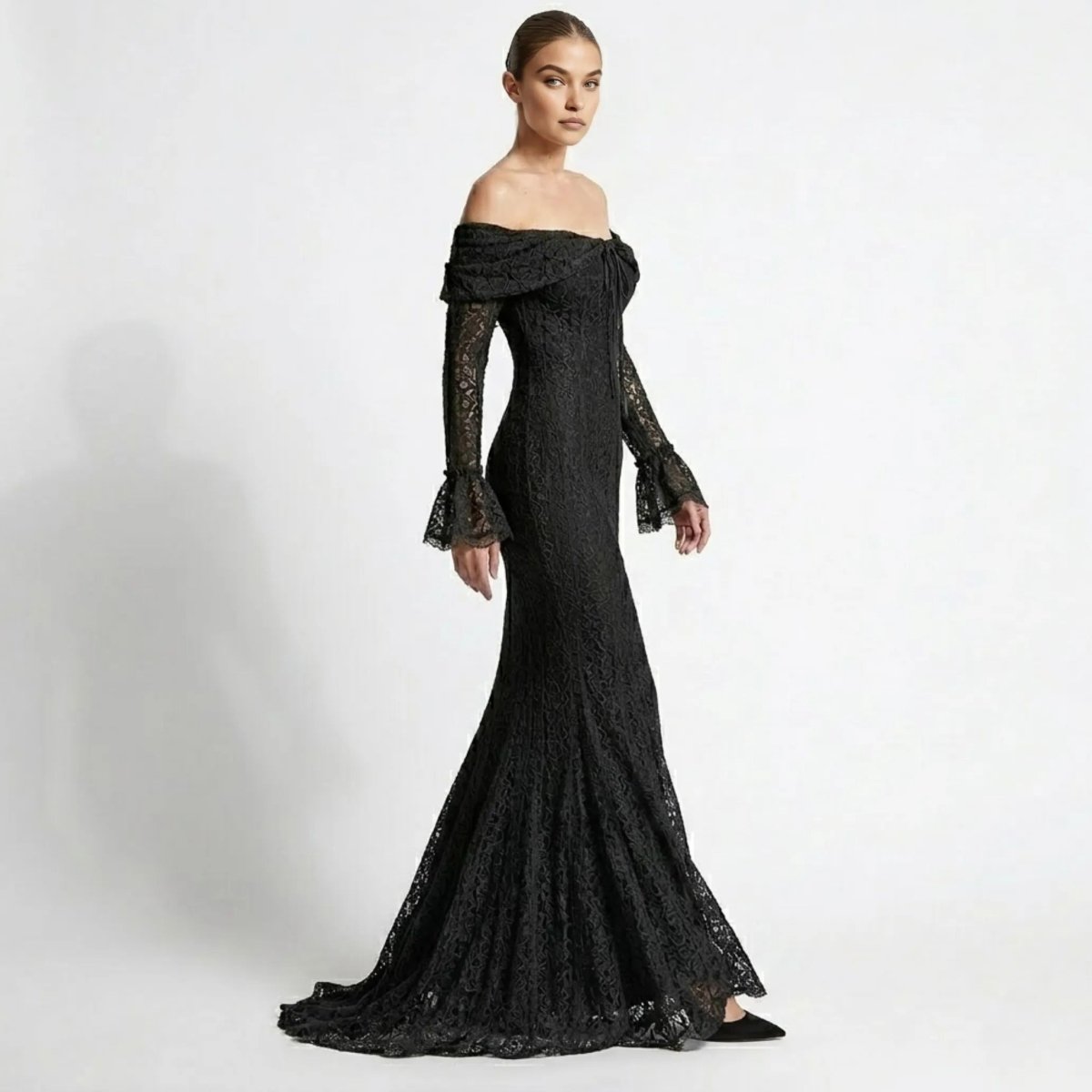 Side profile view highlighting the fitted flattering mermaid silhouette of a black lace formal evening gown