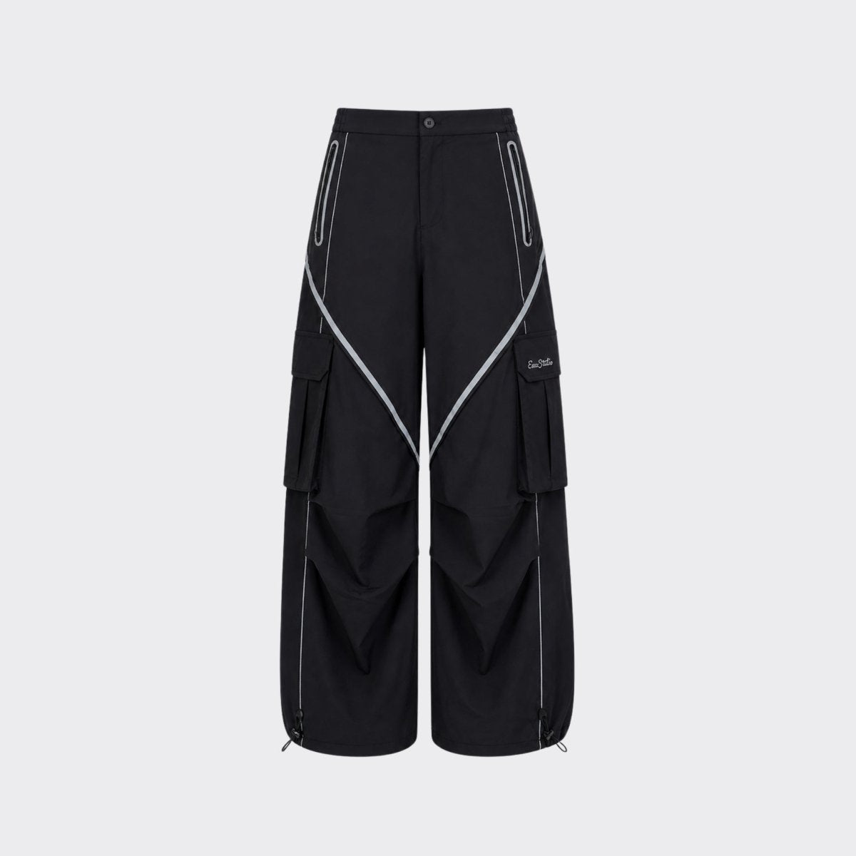Flat lay studio shot of black nylon parachute cargo pants with white reflective contrast piping