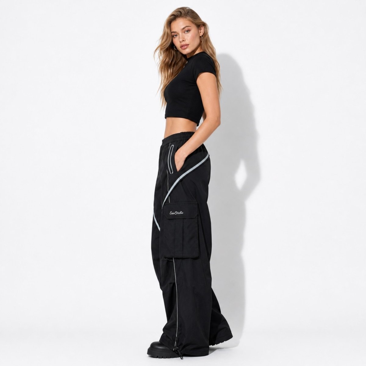 Side profile of black y2k streetwear parachute pants showcasing large functional 3D cargo pockets