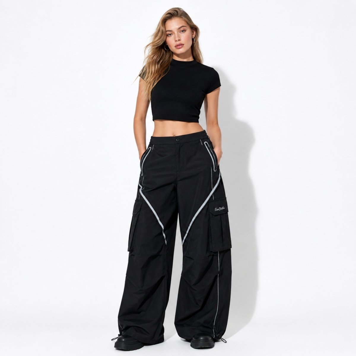 Stylish model wearing black high waisted baggy utility trousers paired with a black crop top and chunky boots