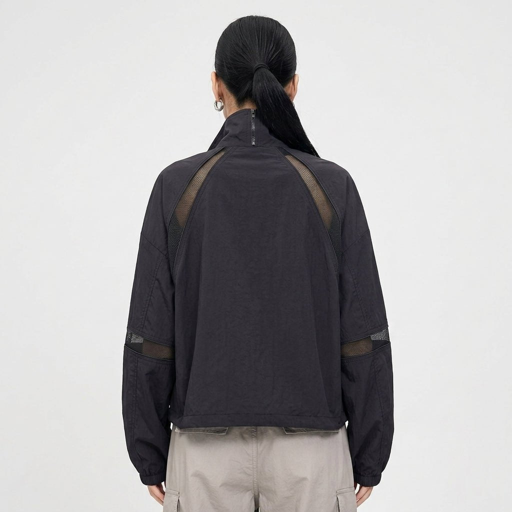 Back view of Kouvr black sporty lightweight jacket showing geometric diagonal mesh shoulder detailing