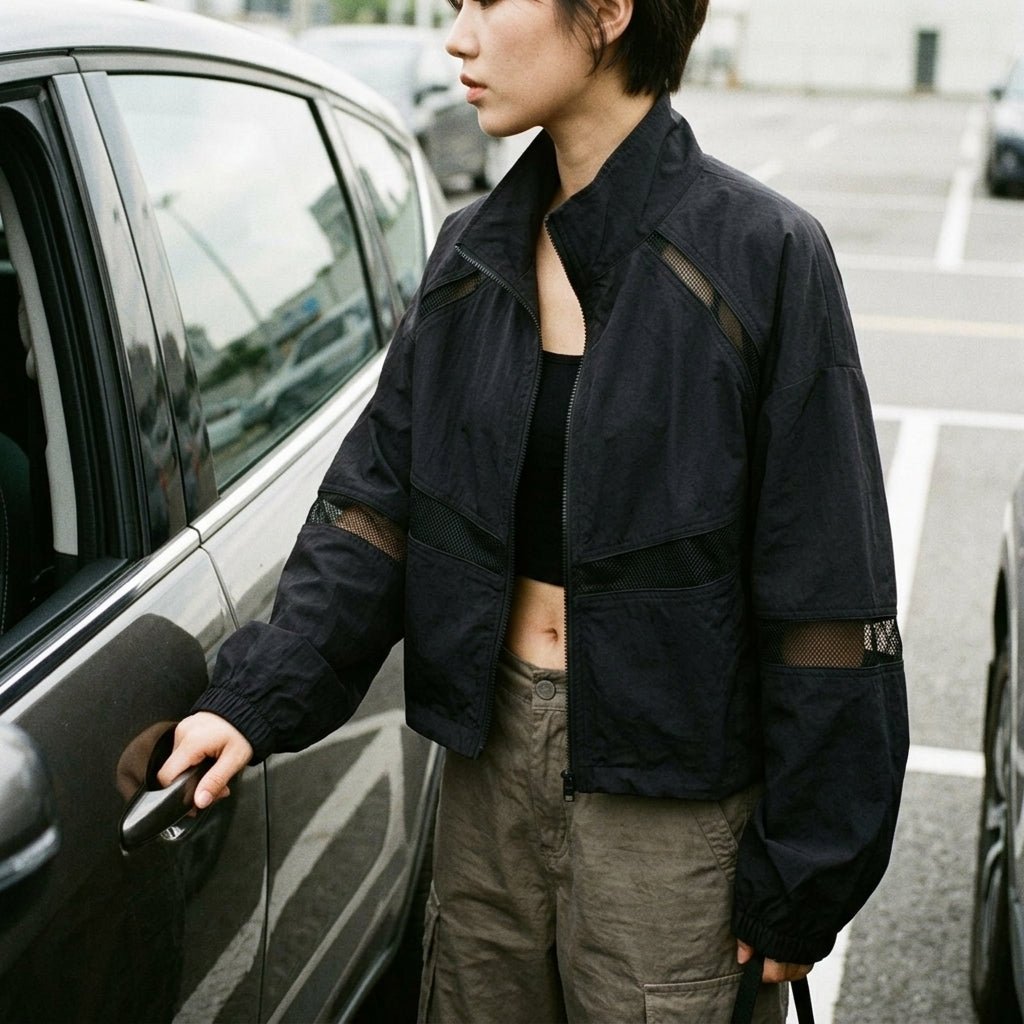 Casual mirror selfie showing how to style the Kouvr black Y2K windbreaker jacket with neutral pants