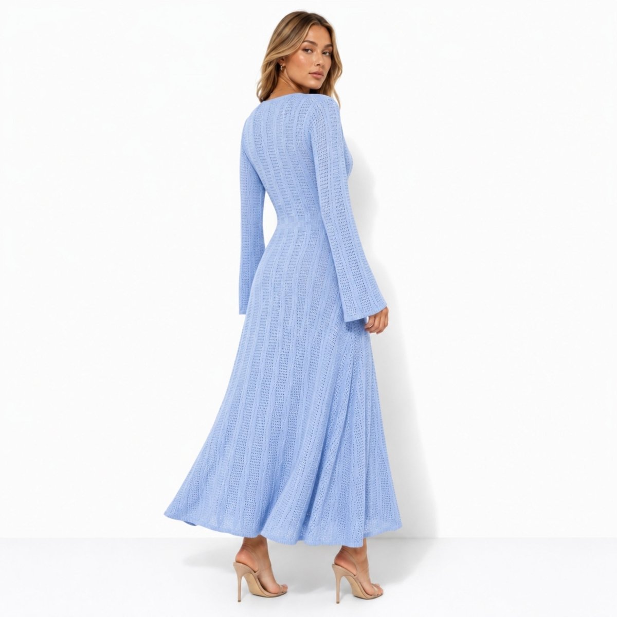 Back view of an elegant light blue long sleeve crochet maxi dress showing the tailored waist fit and flowing textured knit skirt.
