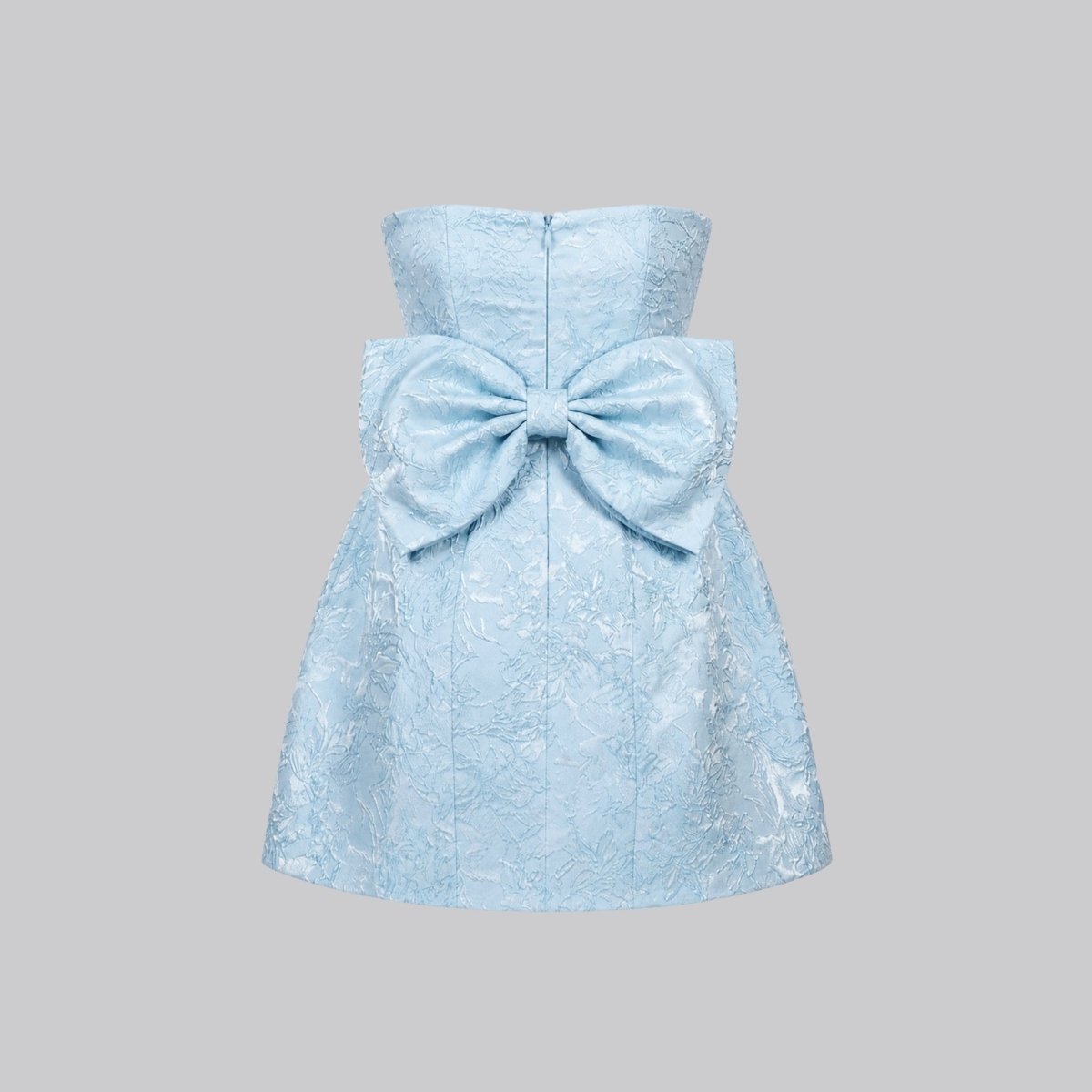 Flat lay back view of the light blue jacquard dress detailing the large structured statement bow and back zipper closure.