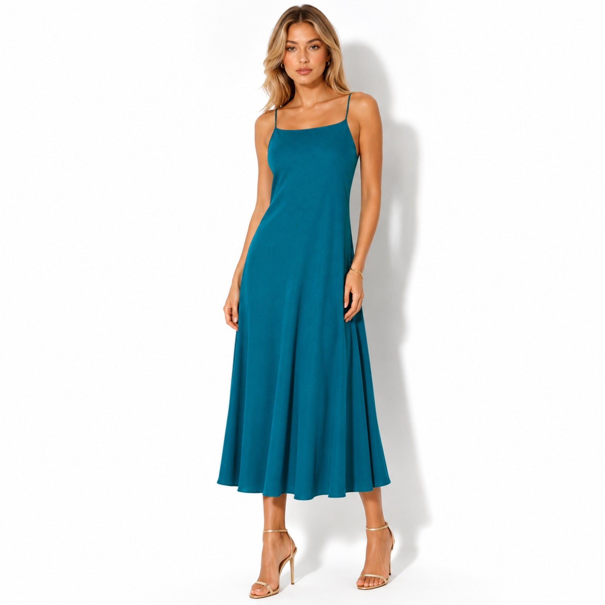 Fashion model wearing an elegant  blue linen midi slip dress with a square neckline and gold heels facing forward.