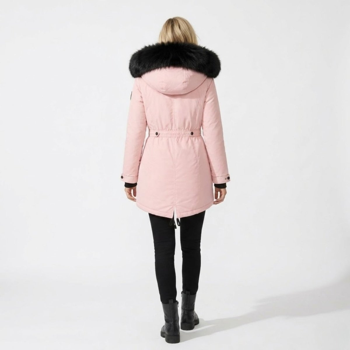 Back view of the Kouvr blush pink winter parka highlighting the drawstring fishtail hem and black faux-fur collar.
