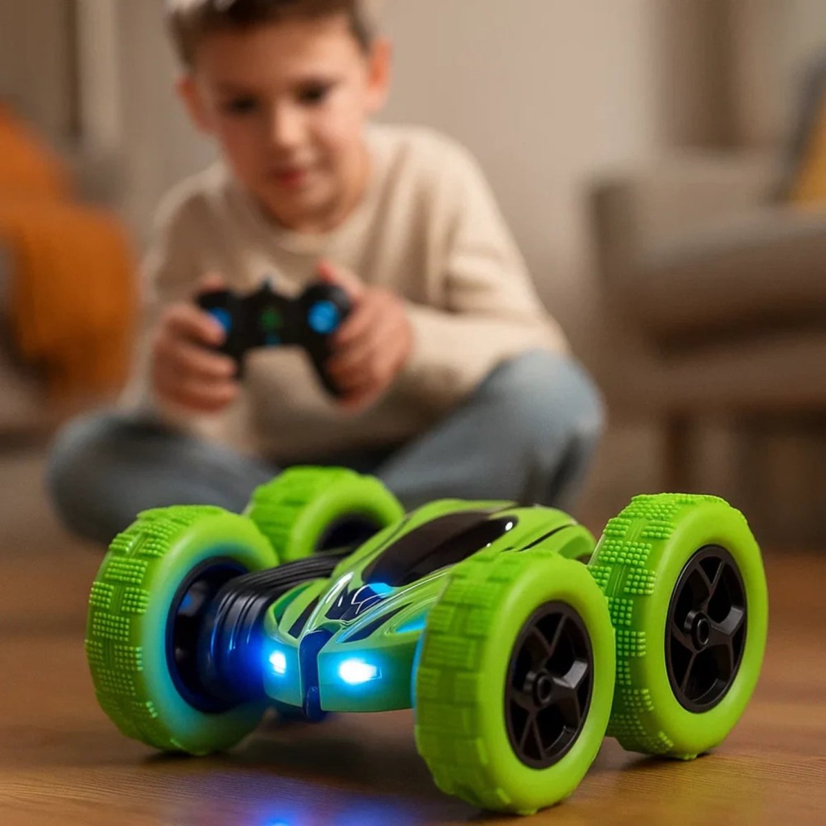 A focused young boy kneels on a suburban street, happily driving the blue Kouvr Cyclone RC stunt car with the remote control.