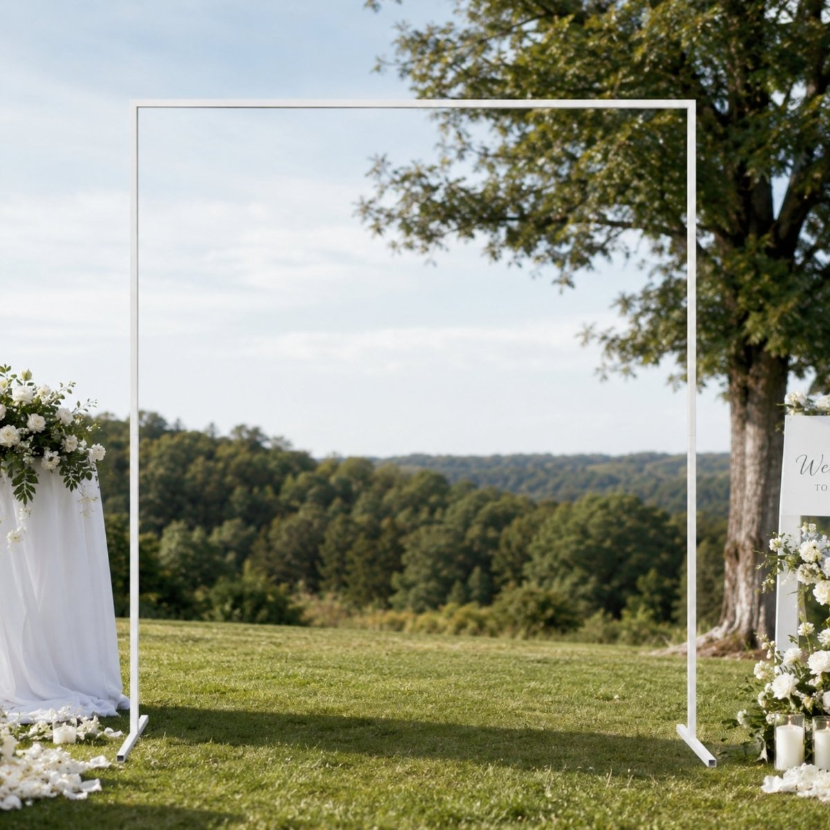 Lifestyle view of a chic white metal wedding archway demonstrating its stable base design on an outdoor event lawn.