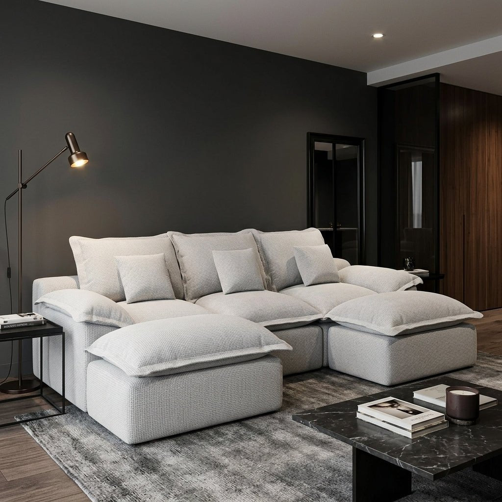 Multi-generational family relaxing and laughing on a comfortable grey modular sectional sofa in a bright living room.