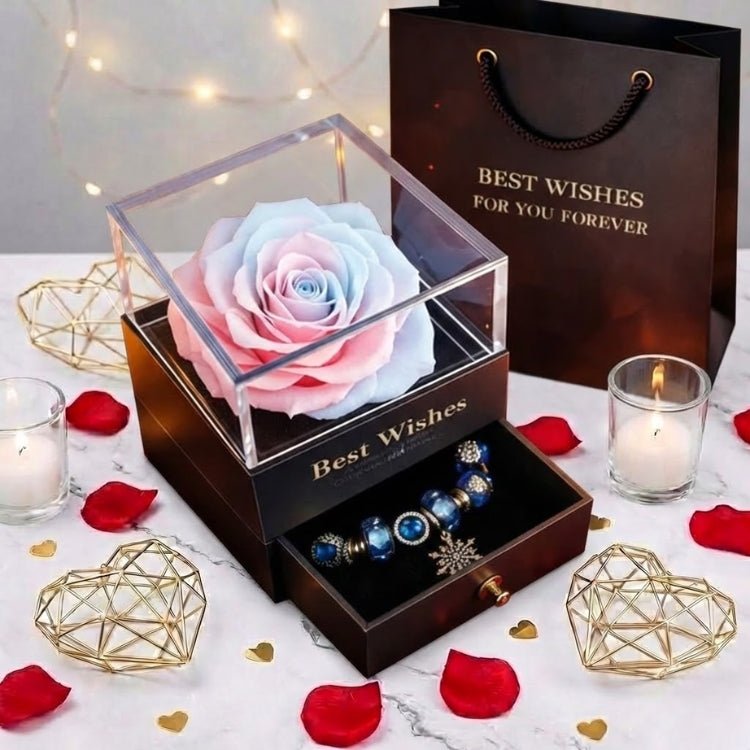 A dreamy cotton candy colored preserved rose gift box displayed with a snowflake charm bracelet and romantic lighting.