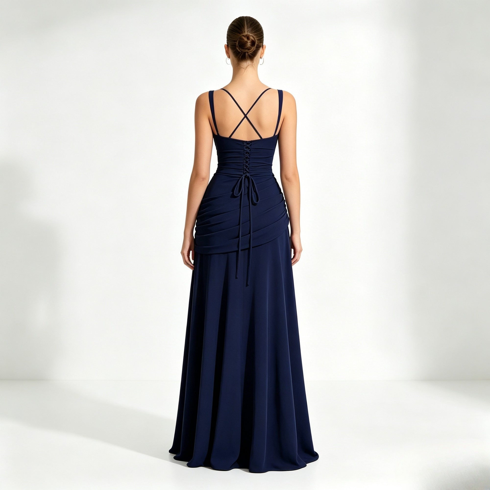 Back view of a dark blue formal dress showcasing an adjustable strappy lace-up corset back and elegant trailing gown fabric.