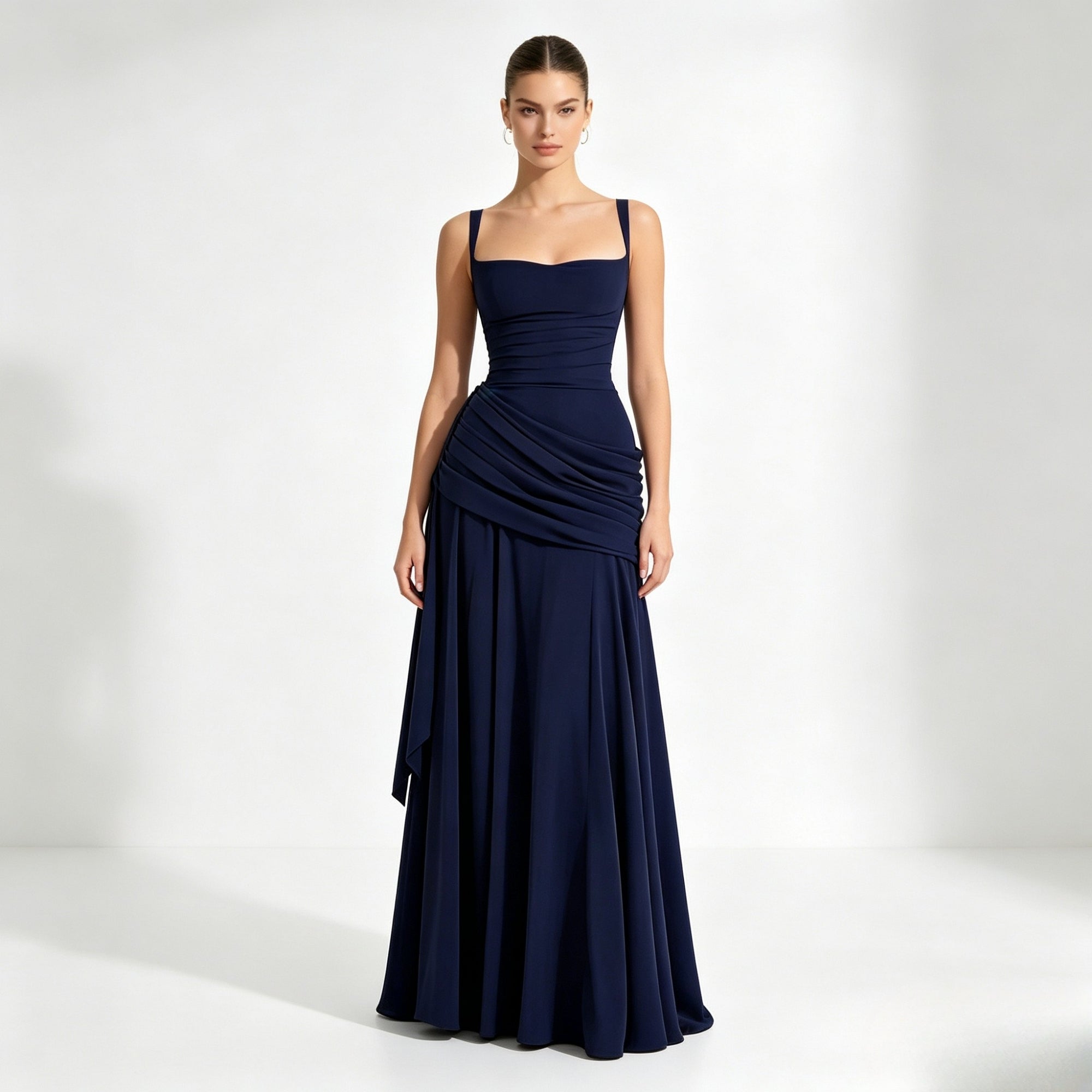 Woman modeling a dark  blue square neck formal evening gown with ruched waist by Kouvr, standing facing forward.