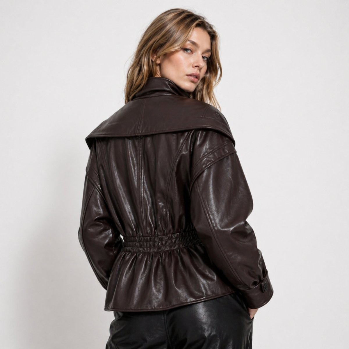 Back view of brown faux leather outerwear showing smocked elastic waist detailing.