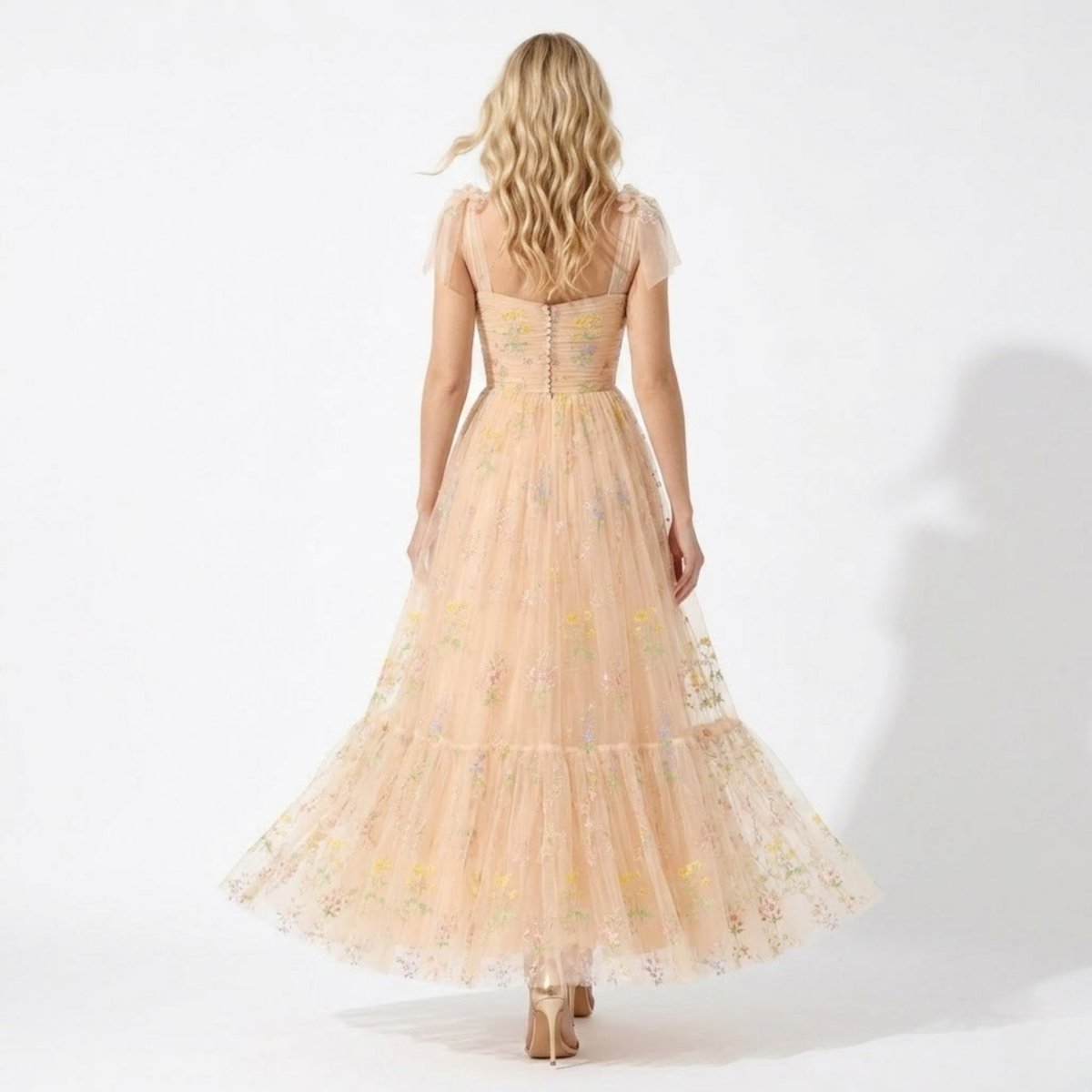 Back view of fairycore romantic tulle gown showing decorative back buttons and flowing tiered skirt.