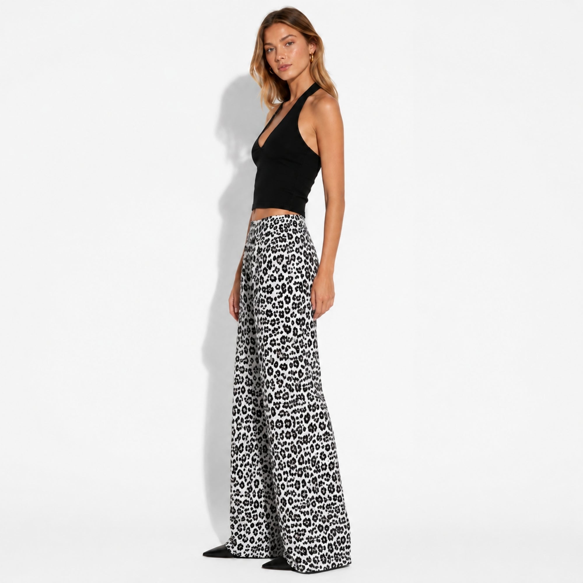 Side profile of woman modeling high waisted flowy leopard print pants demonstrating the relaxed wide leg silhouette