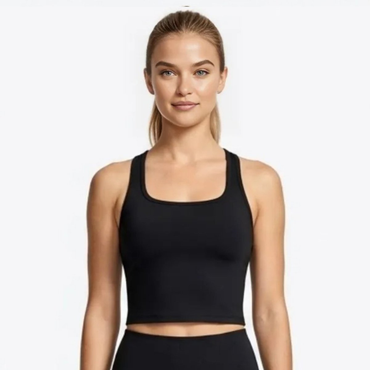 Front view of female model wearing Kouvr premium black square neck activewear crop top and sculpting leggings.
