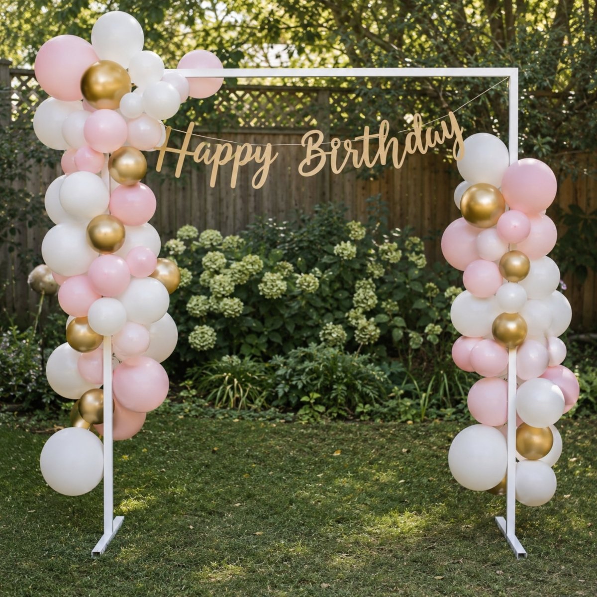 Heavy duty white metal backdrop stand used as a garden party photo area with pink and gold balloon garland decor.
