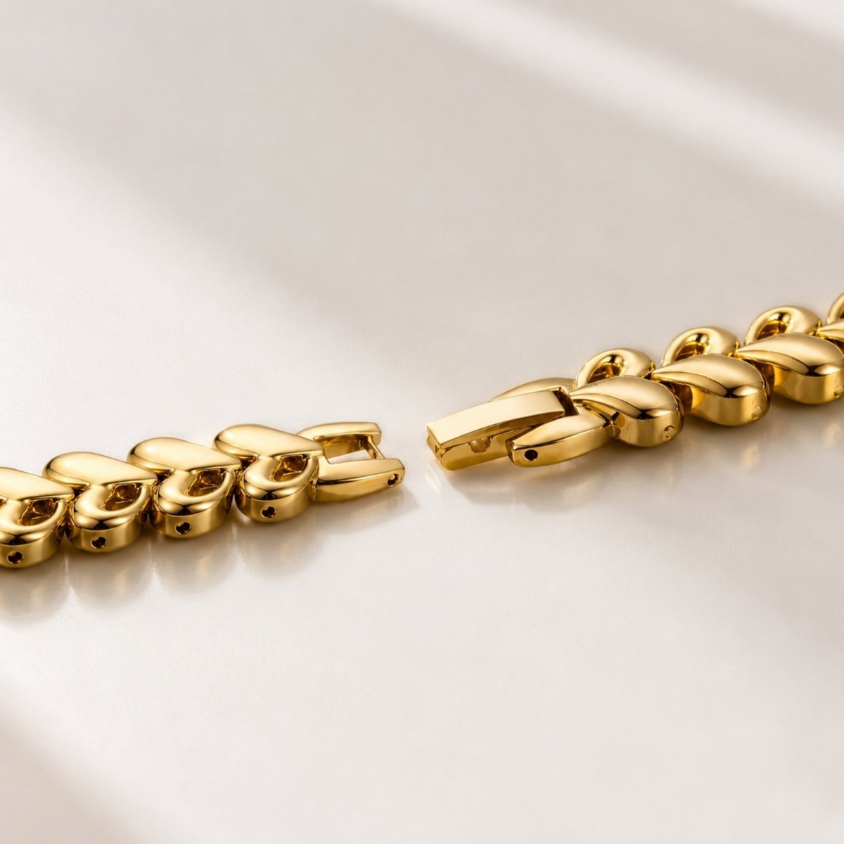 Macro detail shot showing the premium adjustable clasp mechanism and interlocking heart links of the Kouvr gold women's jewelry watch.