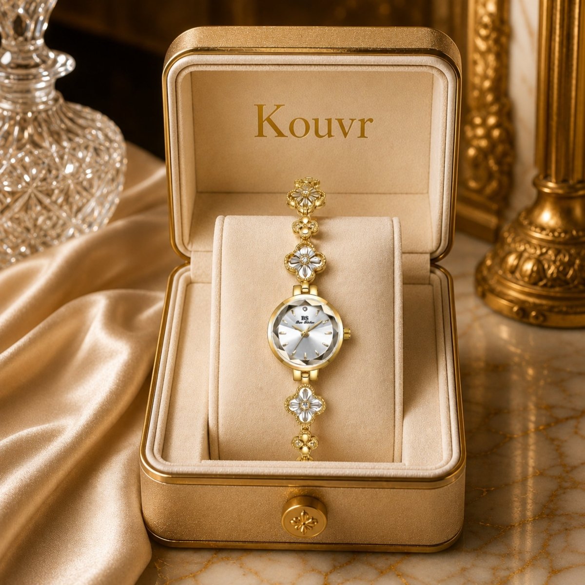 Elegant gold women's clover bracelet watch resting elegantly in a luxurious Kouvr display box alongside satin fabric