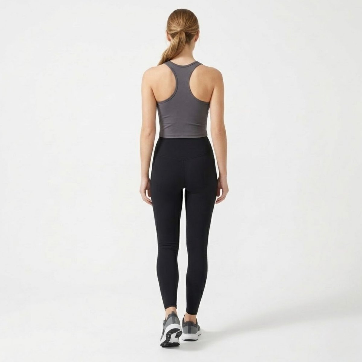 Full body back view showing the supportive racerback design of the charcoal grey workout top.