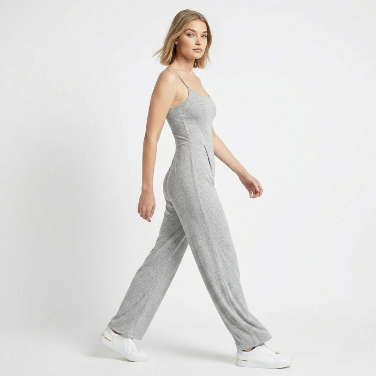 Side view of woman walking in a comfortable stretch grey wide leg lounge jumpsuit by Kouvr
