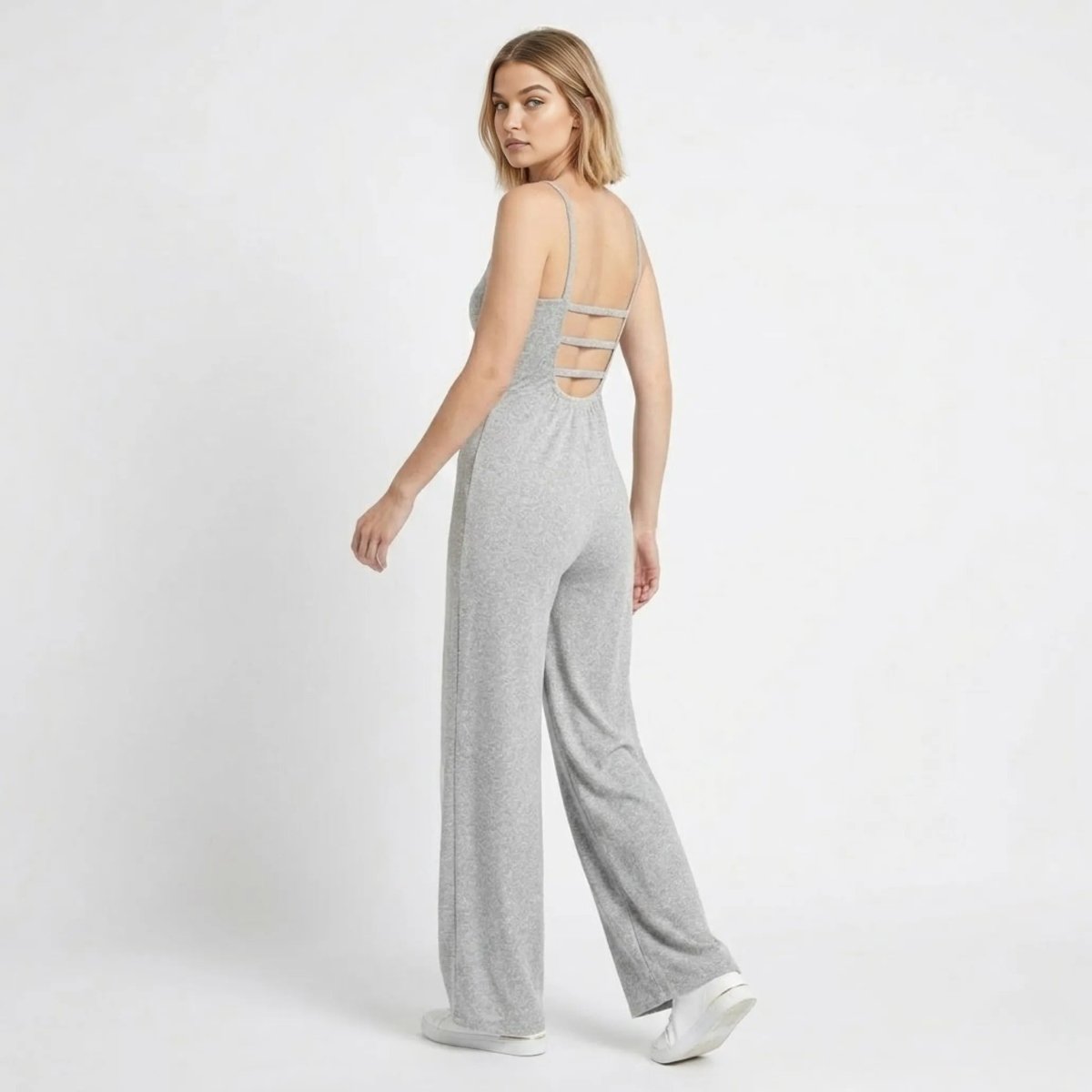 Back view highlighting the ladder strappy open back detail of the grey wide leg knit jumpsuit by Kouvr
