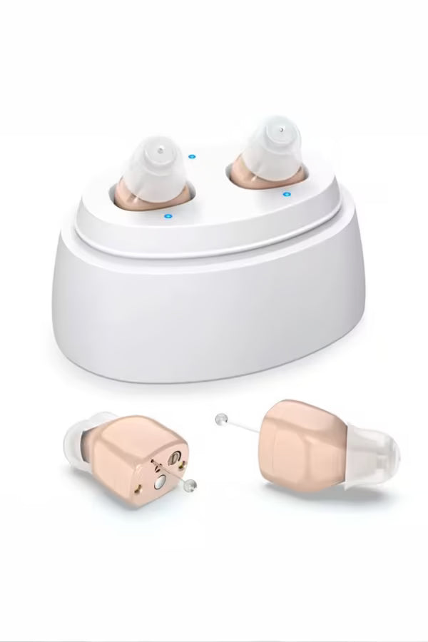 Rose gold hearing aids with charging base on a white background