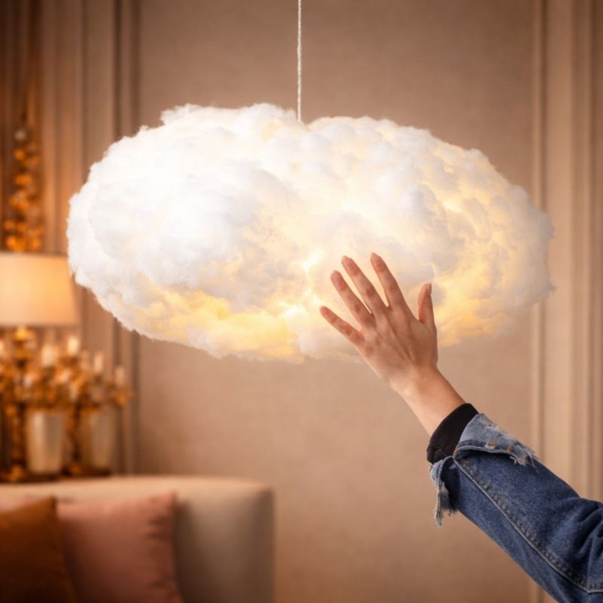 A hand touching the soft, fluffy exterior of an LED cloud lamp to demonstrate the tactile cotton-like material.