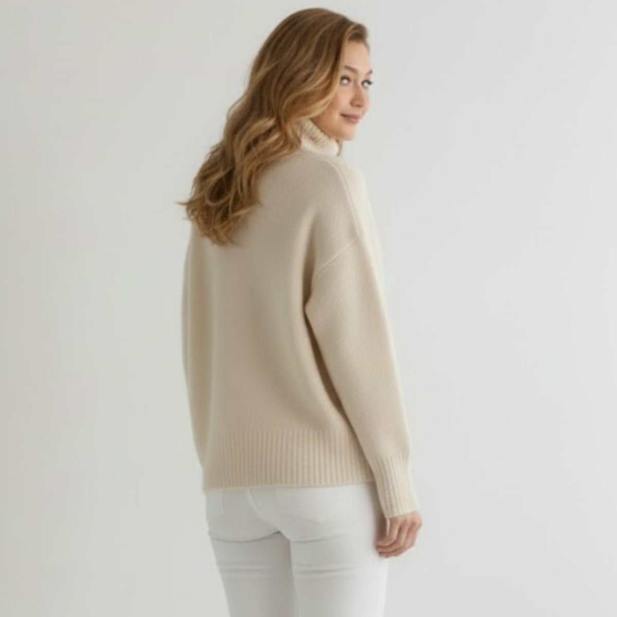 Back view of the Kouvr 100% cashmere turtleneck sweater in beige, highlighting its seamless construction.