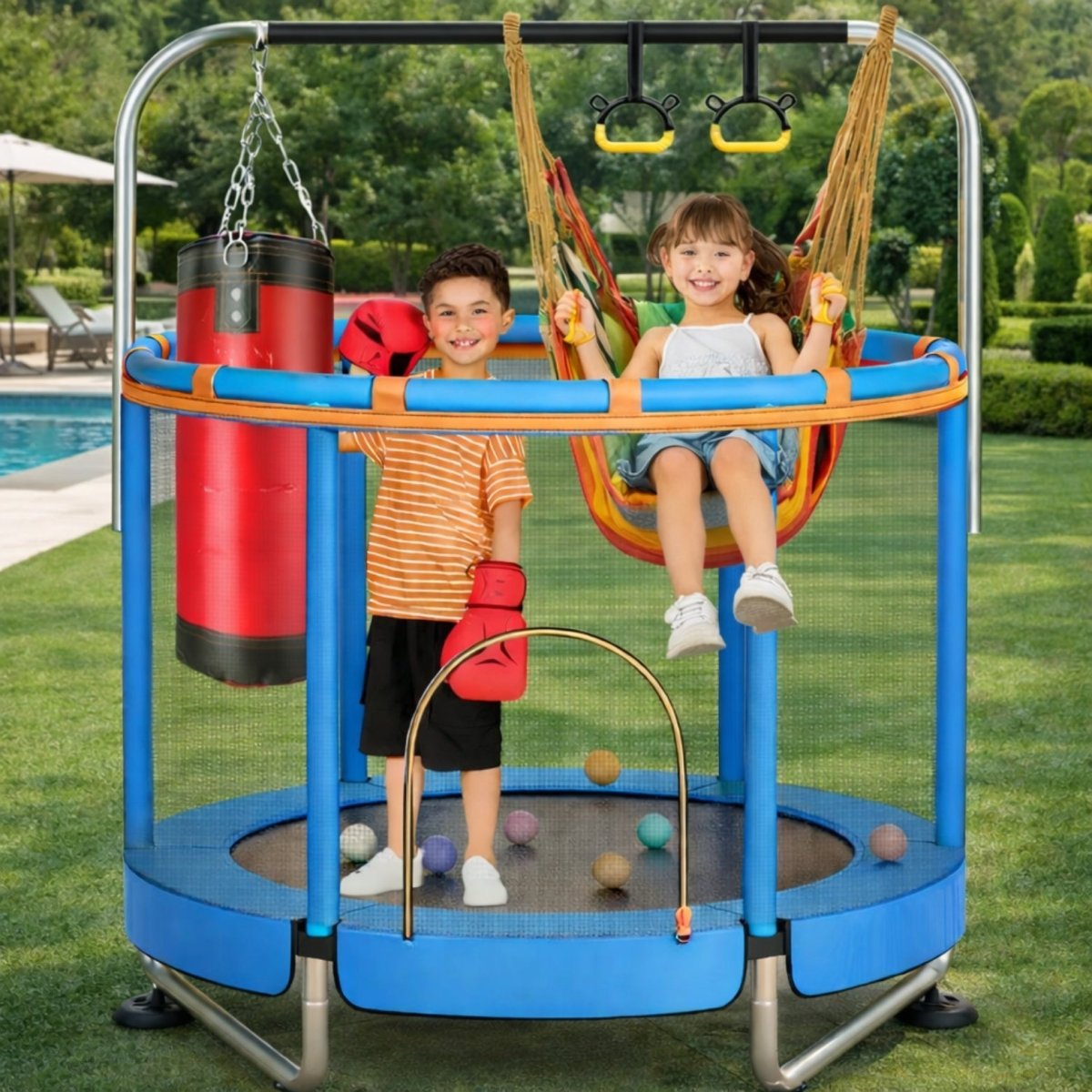Two smiling children on a blue Kouvr 4-in-1 trampoline and swing set with a punching bag, set up in a backyard next to a swimming pool.