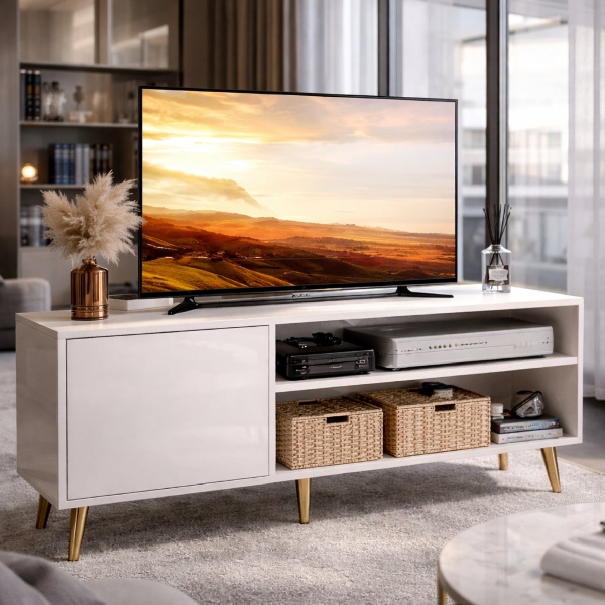 The elegant Kouvr Aalto white media console shown with sophisticated gold-finished legs, styled with wicker baskets and media devices in a contemporary living space.
