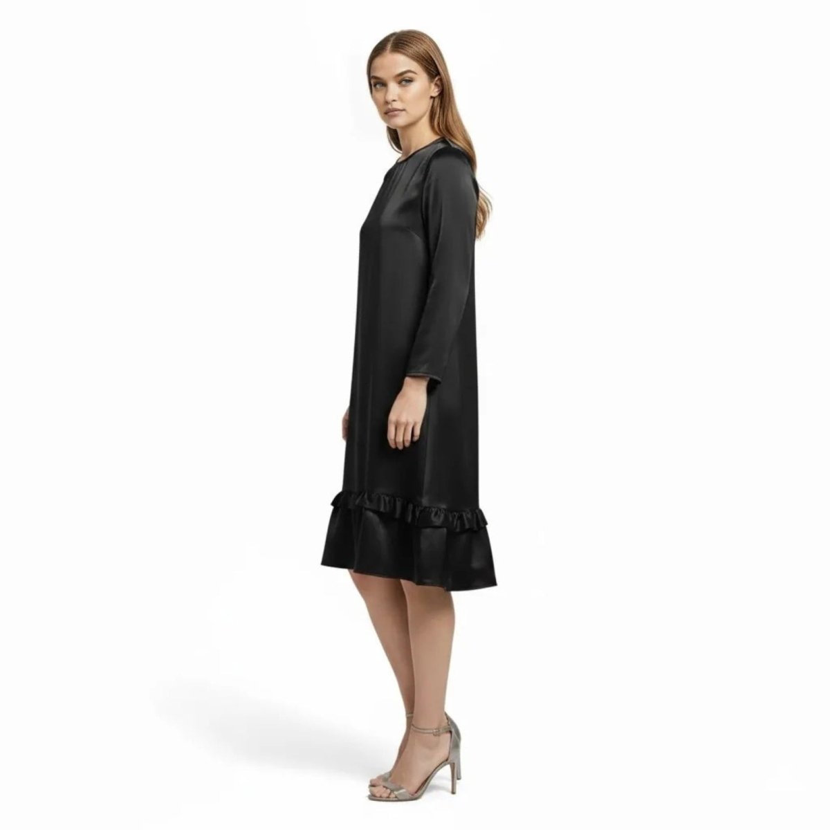 Side profile of a model in a black A-line satin cocktail dress with long sleeves and a ruffled hem.