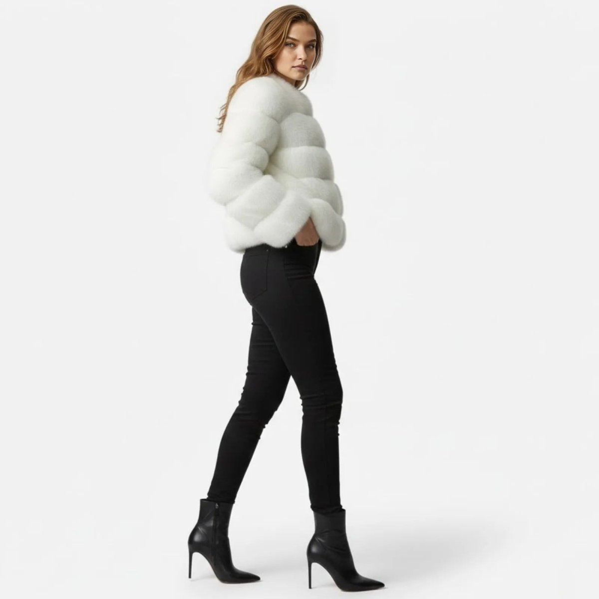 Model in a side profile walking pose wearing the Kouvr Alexia white tiered faux fur jacket, showing its silhouette and volume.
