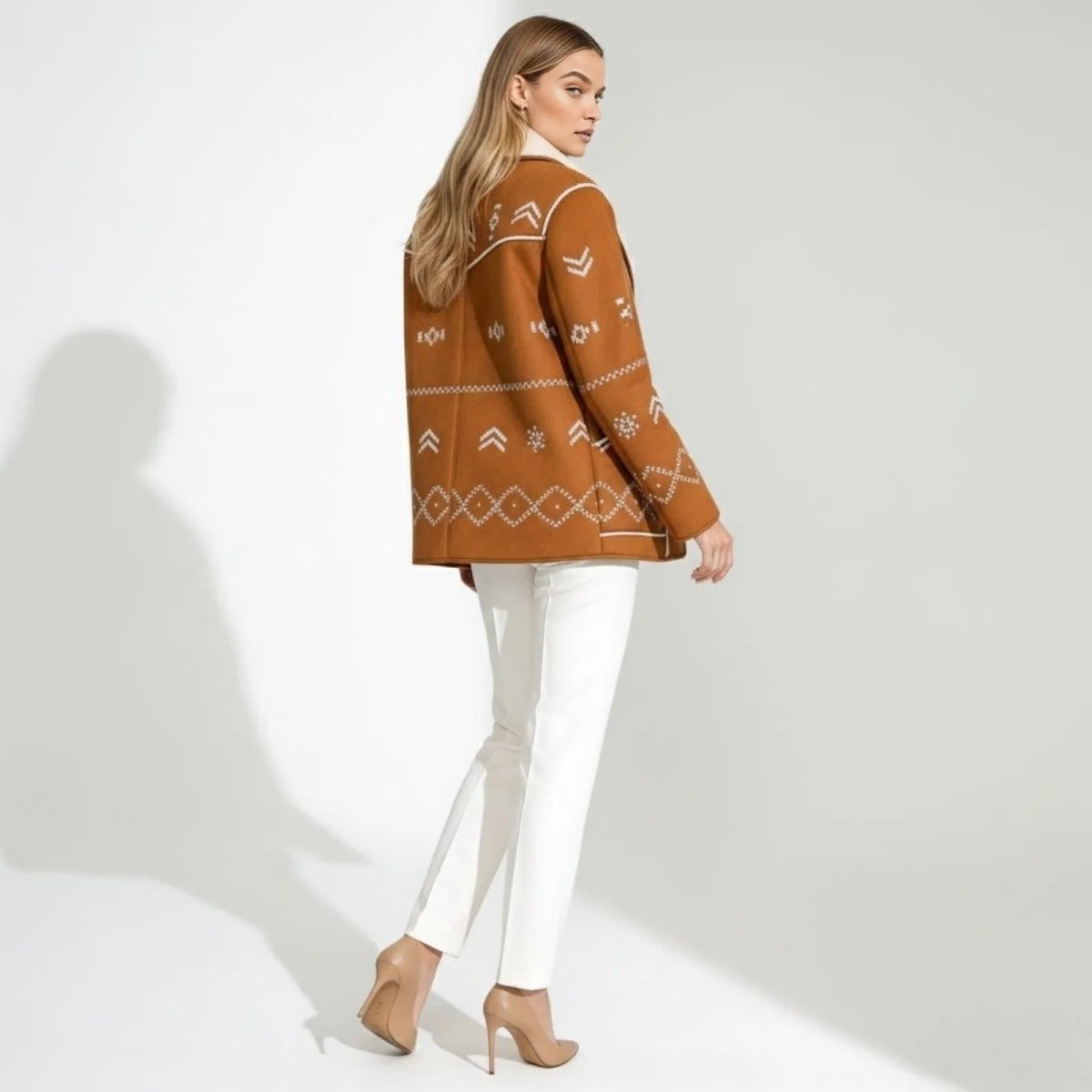 Back view of the Kouvr Alice jacket showing intricate white geometric embroidery across the shoulders and hem.