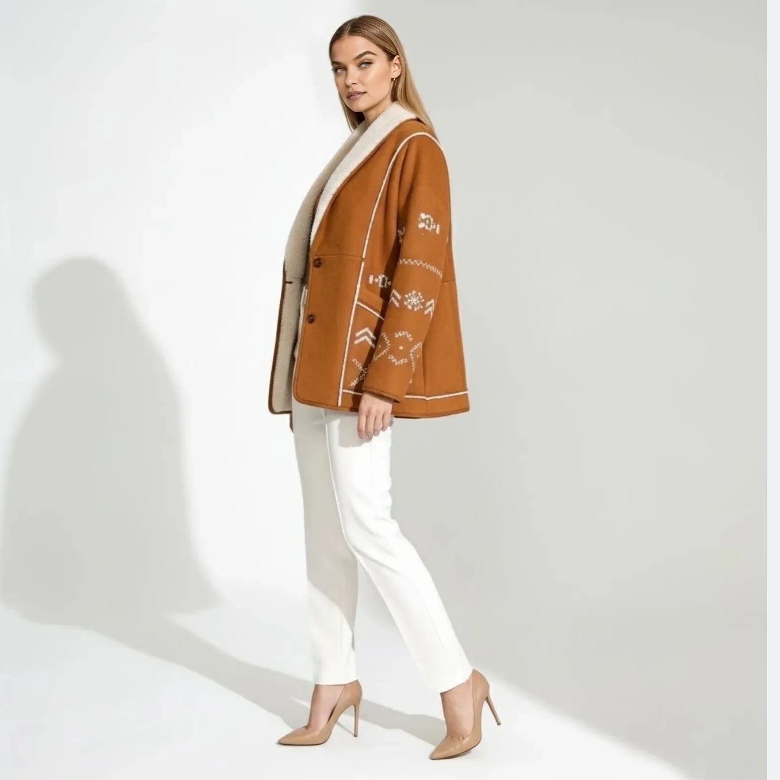 Side profile of a woman wearing a caramel suede jacket with white Aztec embroidery detail on the sleeve.