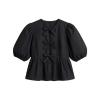 Flat lay of a black cotton poplin top with three bows down the front and voluminous puff sleeves.