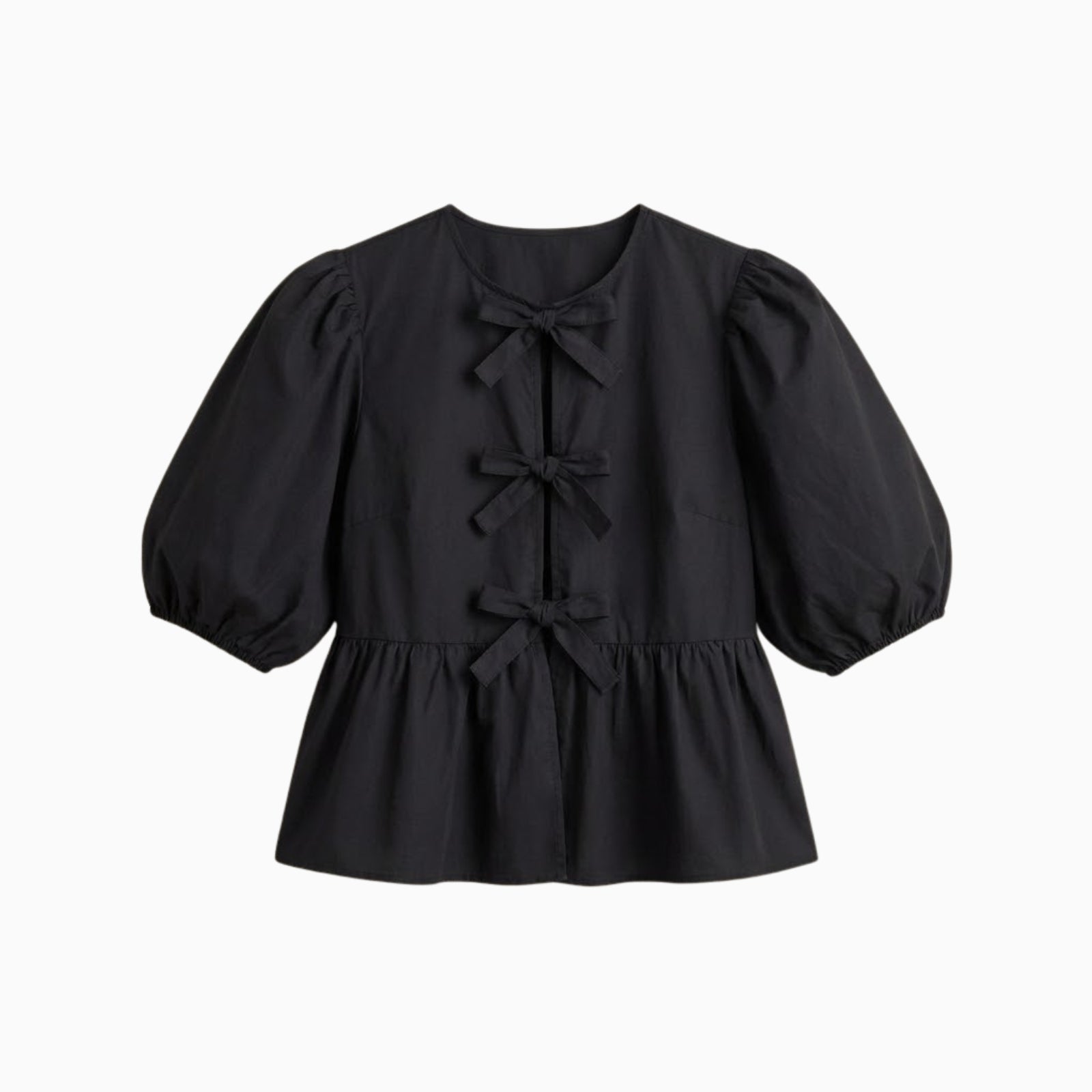 Flat lay of a black cotton poplin top with three bows down the front and voluminous puff sleeves.