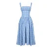 Model wearing the Kouvr Apolline blue gingham midi dress with a structured corset bodice and square neckline, standing in a garden