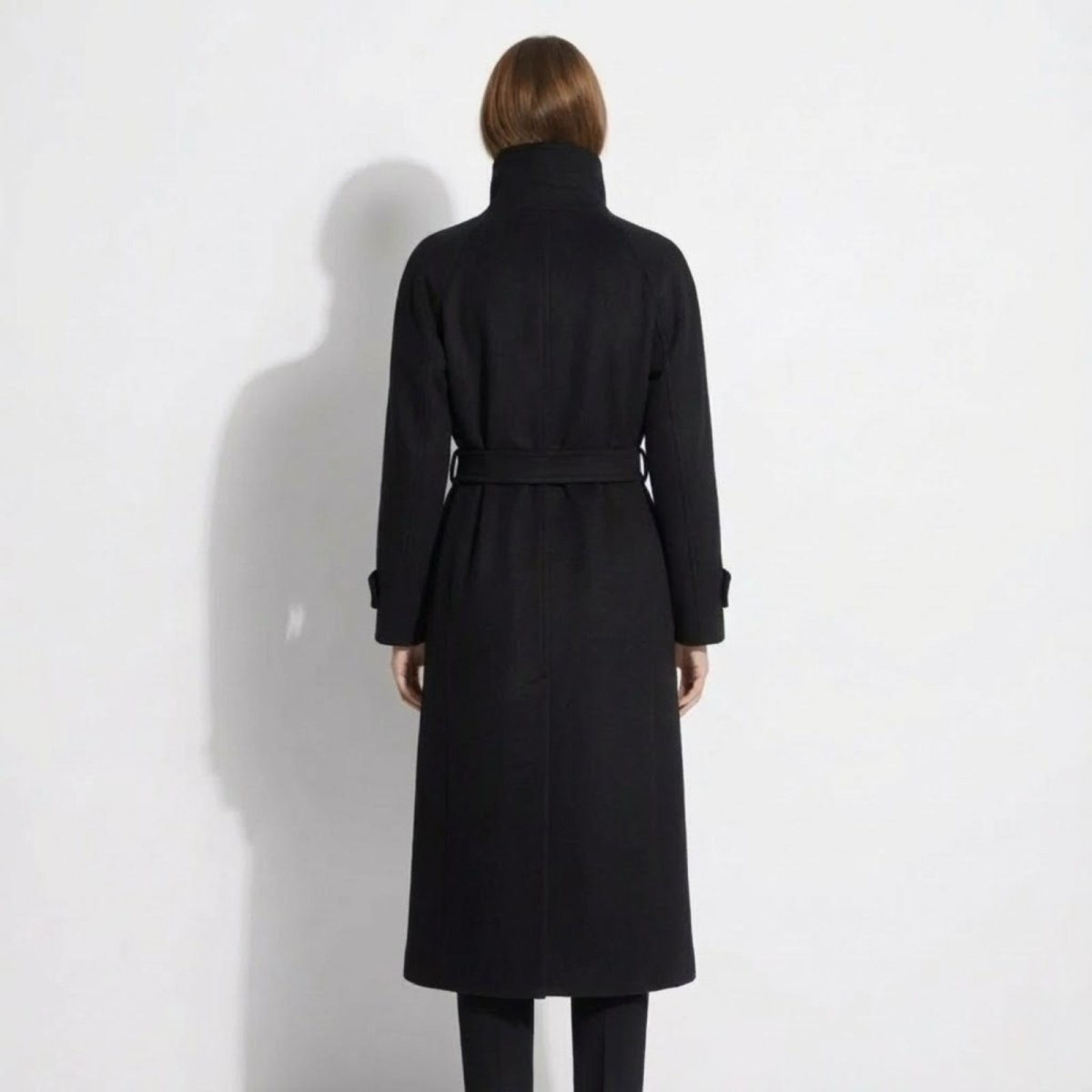 Back view of the Kouvr Ashley black wool coat, highlighting the raglan sleeves and belted waist.