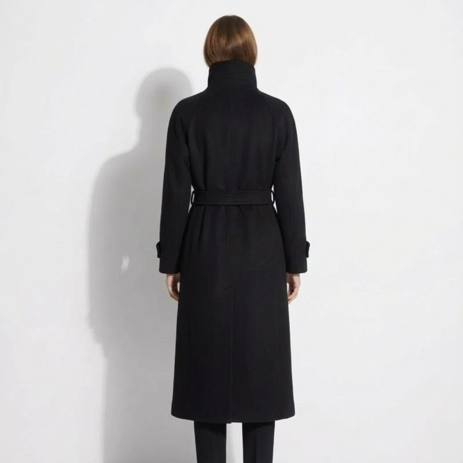 Back view of the Kouvr Ashley black wool coat, highlighting the raglan sleeves and belted waist.