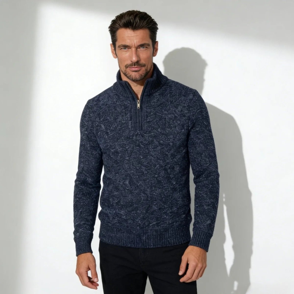 Man wearing the Kouvr Elyson men's textured quarter-zip sweater in a deep navy marl, styled with black trousers.