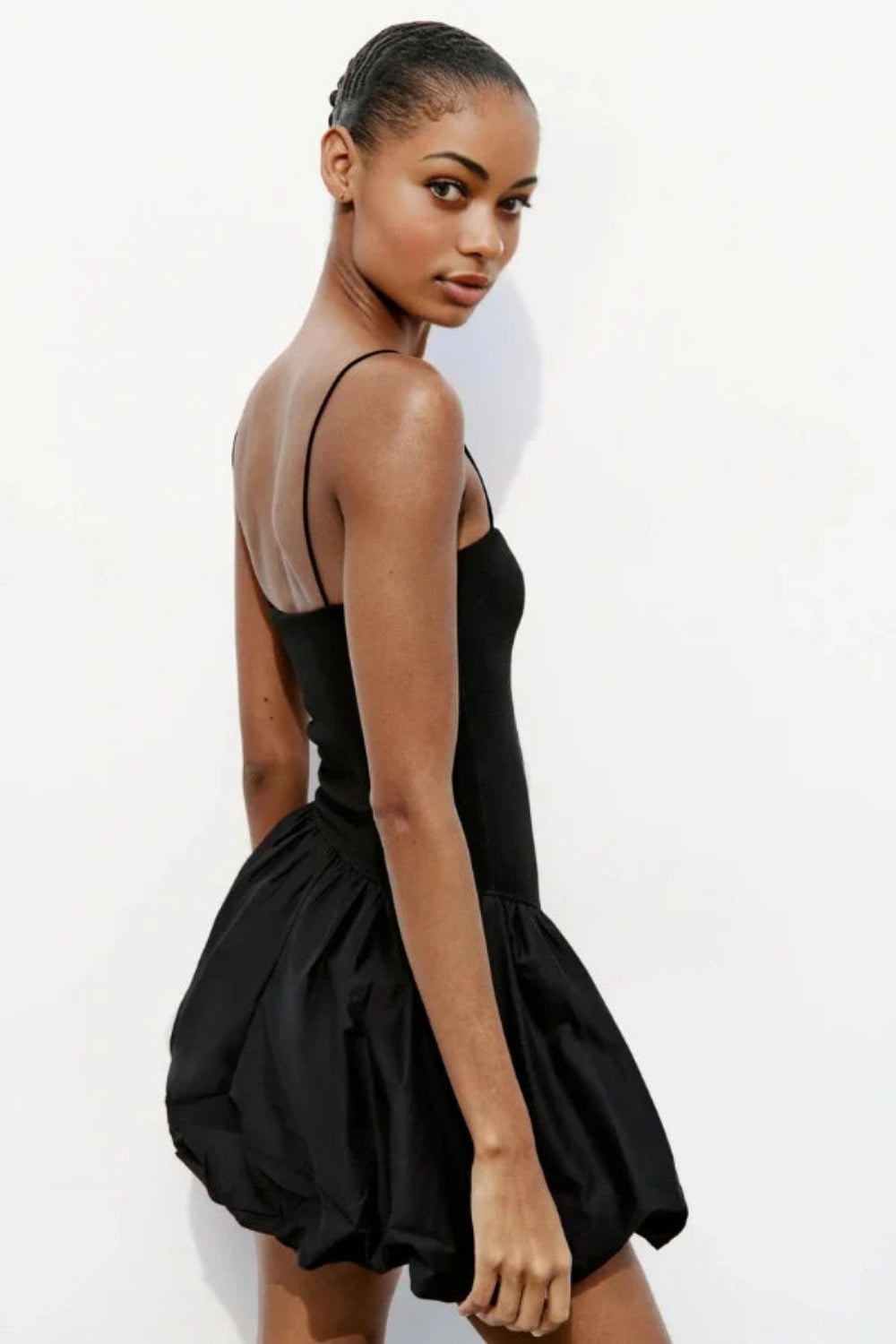 Model wearing the Kouvr Aubrey black mini dress with a voluminous bubble skirt and square neckline