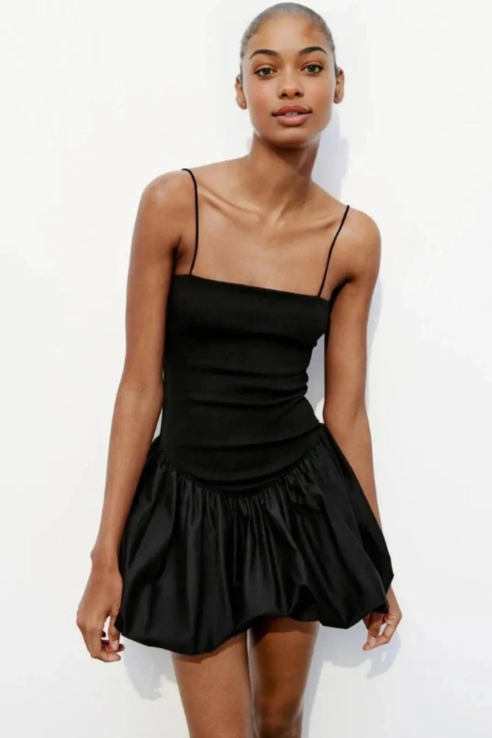Model wearing the Kouvr Aubrey black mini dress with a voluminous bubble skirt and square neckline