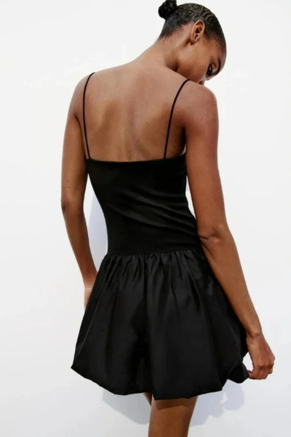 Model wearing the Kouvr Aubrey black mini dress with a voluminous bubble skirt and square neckline