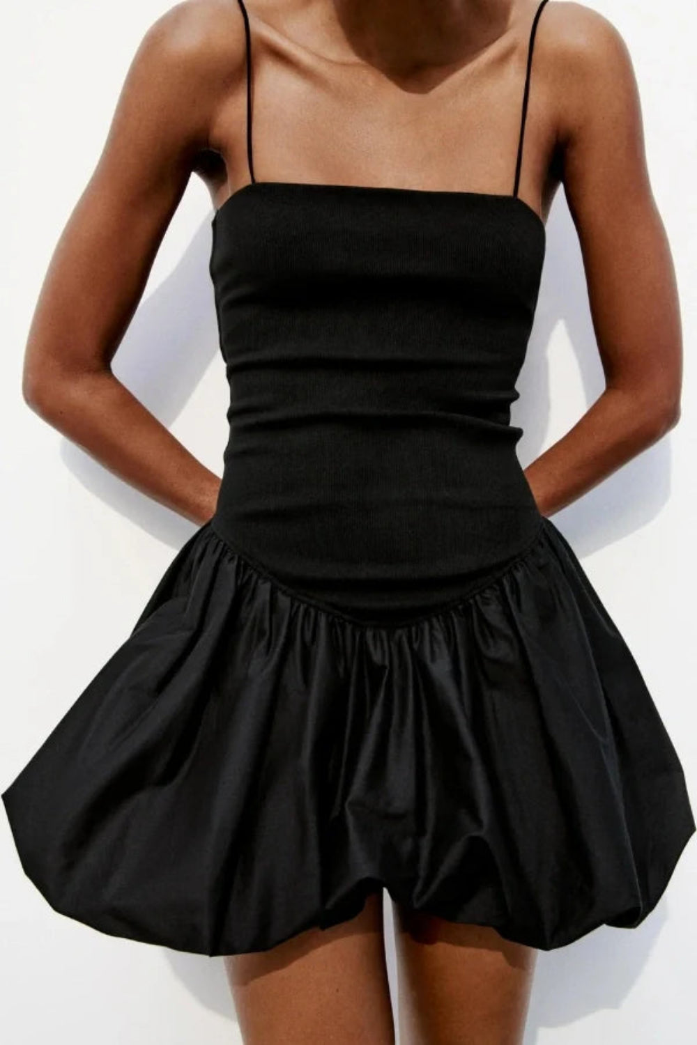Model wearing the Kouvr Aubrey black mini dress with a voluminous bubble skirt and square neckline